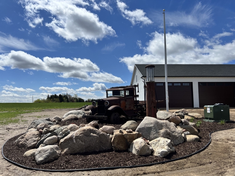 Large stone fieldstone retaining wall to showcase antique truck and fuel pump