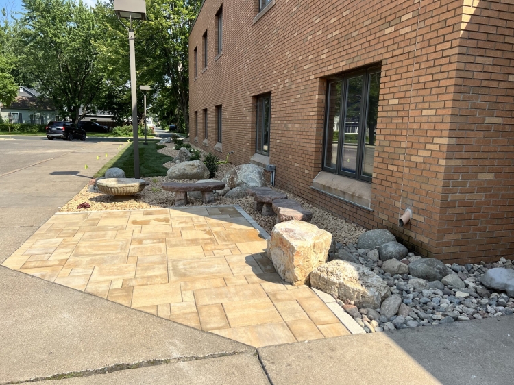 Beautiful landscape renovation for Our Saviors Luthern Church.  Project includes landscaping, planting, lawn restoration, fieldstone boulder outcroppings, and a paver patio with seating boulder and stone benches.