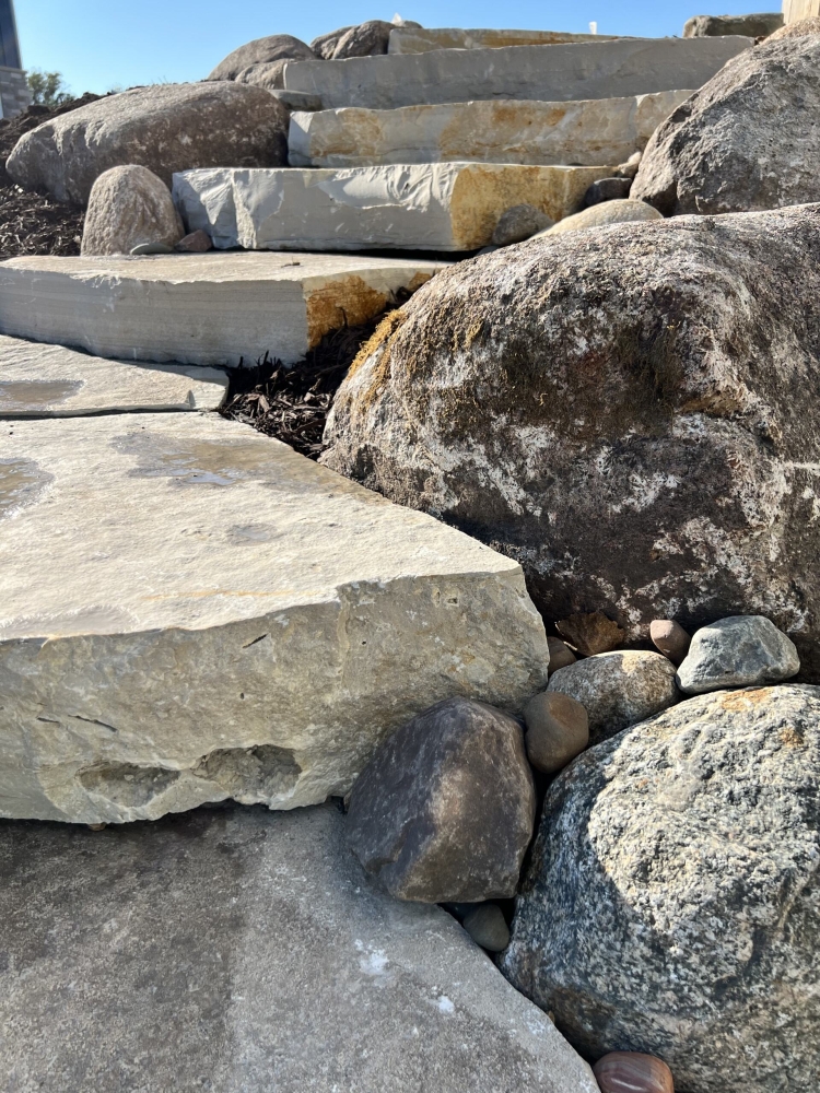 Large Eden irregular stone steps with fieldstone boulder outcroppings and Eden flagstone landing pad.