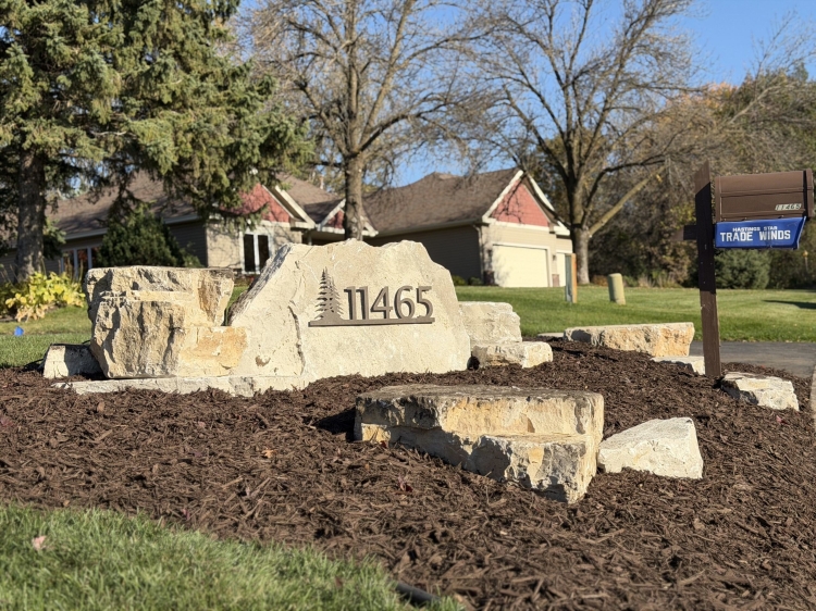 Eden stone address marker with large Eden boulder outcroppings in landscaping bed.