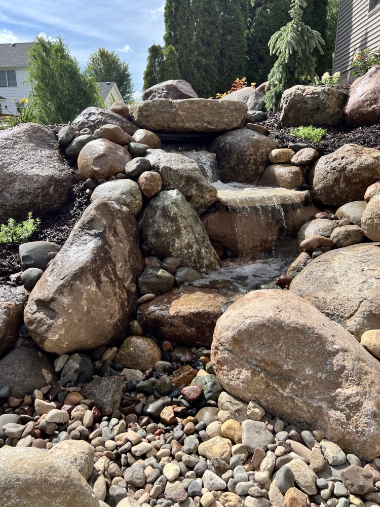 Beautiful plantings around a pond-less water feature.