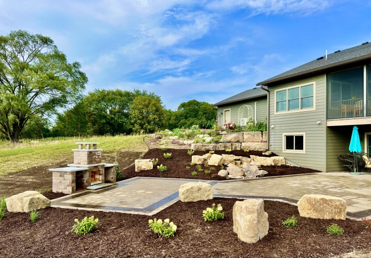 Beautiful landscaping beds around patio area overlooking horse pasture and native field.