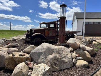 Large fieldstone boulder retaining wall to showcase these beautiful automotive antiques. 