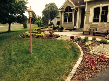 Beautiful entryway planting with lots of color from perennials, shrubs and evergreens with fieldstone boulder outcroppings