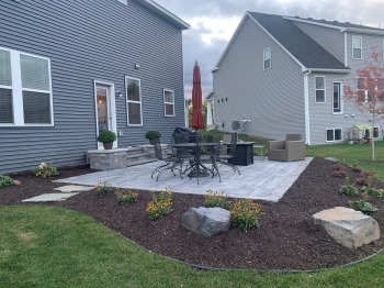Slab style paver patio with walkout steps with pillars.