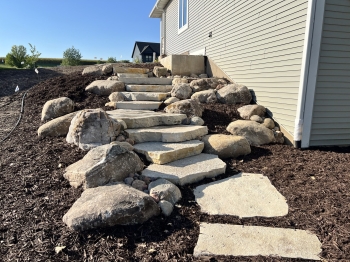 Large Eden irregular stone steps with fieldstone boulder outcroppings and Eden flagstone landing pad.
