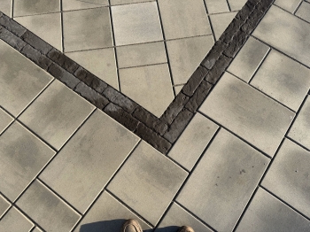 Techo bloc 3-Piece slab paver set with textured charcoal border. 
