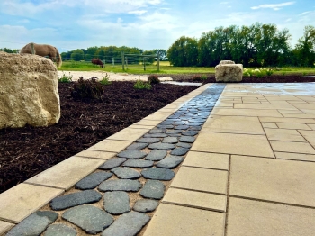 Beautiful county materials - elements paver patio with cobble paver border accent. Patio overlooks a breathtaking horse pasture and native prairie giving our customer the perfect place to enjoy everything they love in life.