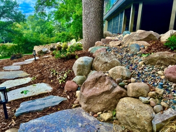 Eden flagstone stepper walkway through beautiful landscape garden.