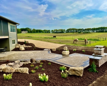 Beautiful landscaping beds around patio area overlooking horse pasture and native field. 