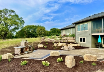 Beautiful landscaping beds around patio area overlooking horse pasture and native field. 